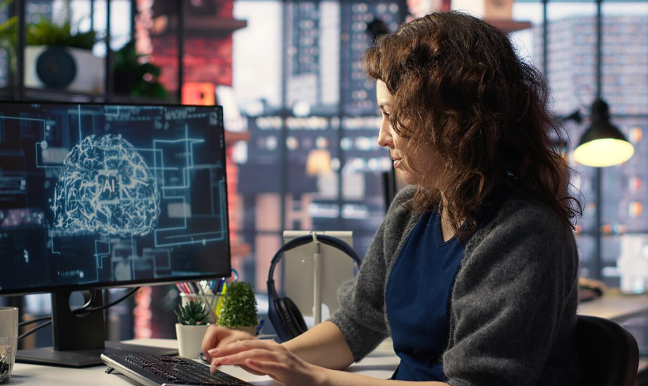Creator working at a computer with an AI brain graphic on screen, illustrating ethical use of AI in creative work.