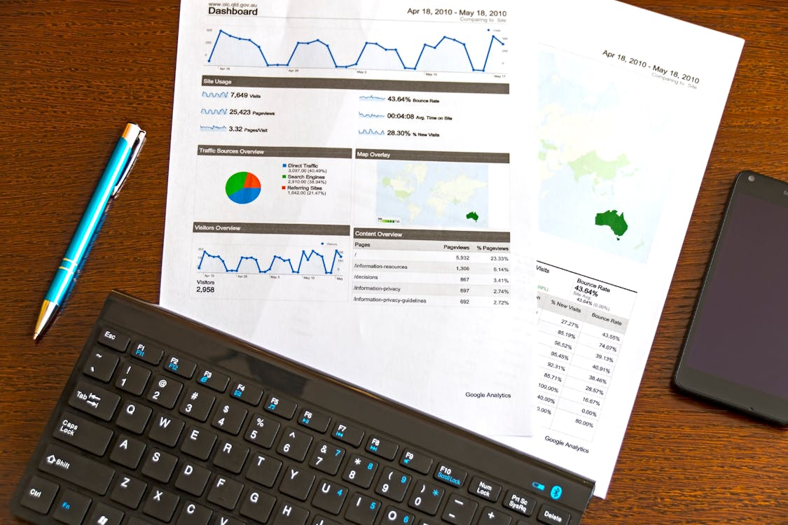 Printed website analytics reports on a desk showing simple analytics for creators reviewing audience data.